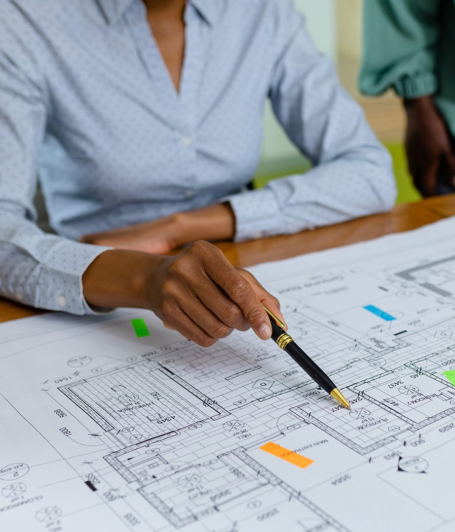 Midsection of african american female architects analyzing blueprint on desk in office, copy space. Unaltered, architecture, construction industry, design, teamwork, paper, hand and business concept.