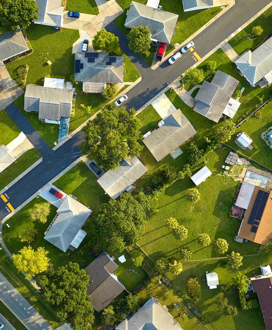 Aerial view of small town America suburban landscape with private homes between green palm trees in Florida quiet residential area.